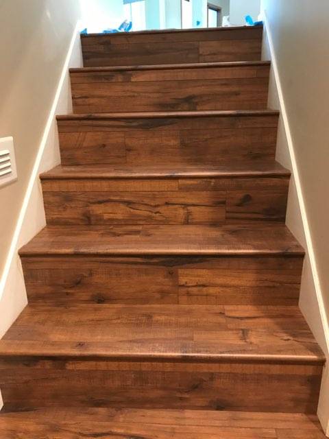 A staircase with wood flooring on it.