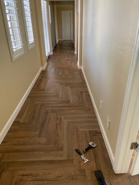 A hallway with wood flooring and a door.