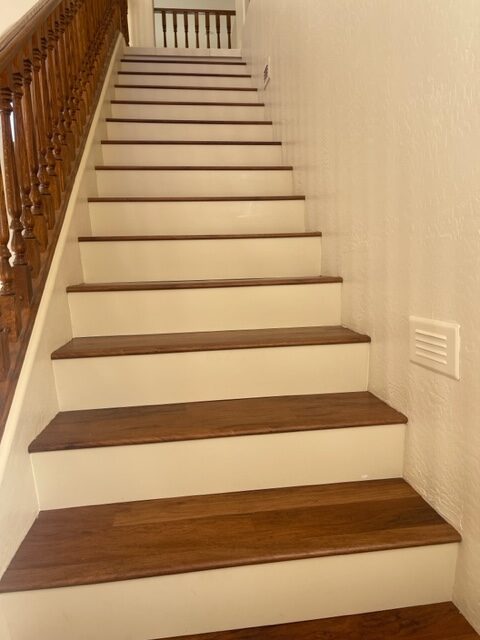 A white staircase with wooden treads and railings.
