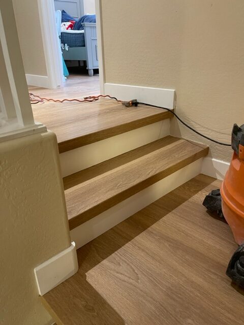A vacuum is being used to clean the stairs in a house.