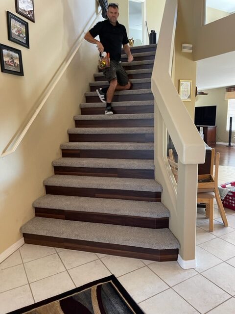 A man is standing on the stairs in a home.